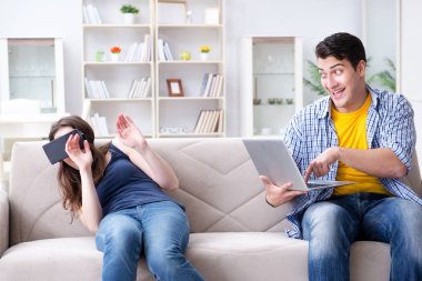 Genç bir aile sanal gerçeklik gözlükleriyle oyun oynuyor.