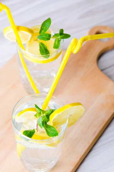 Glasss of mojito with lemon and drinking straw — Stock Photo, Image