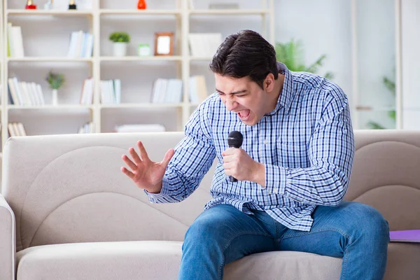 Evde karaoke yapan komik adam.