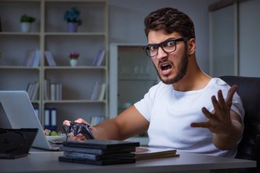 Genç adam ofiste saatlerce oyun oynuyor.