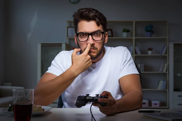 Молодий чоловік грає в ігри на довгі години пізно в офісі — стокове фото