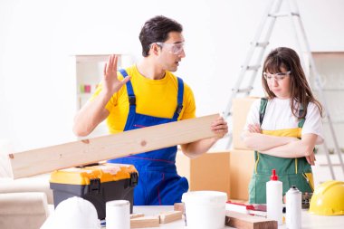 Ahşap atölyesinde kadın marangozluk ipuçlarını açıklayan adam