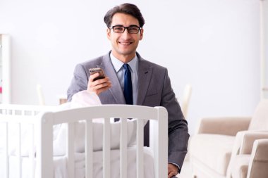 Genç işadamı yeni doğduktan sonra evde çalışmaya çalışıyor.