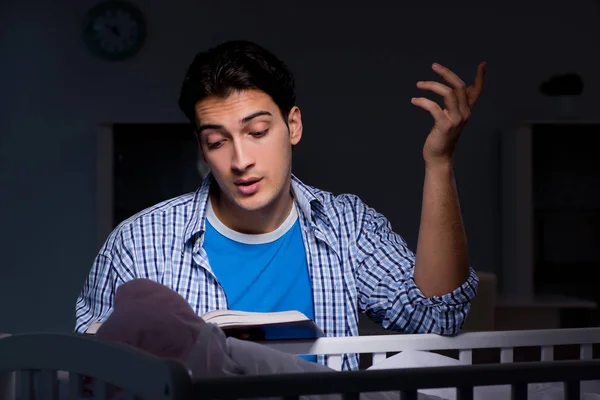 Joven estudiante haciendo deberes y cuidando al bebé recién nacido — Foto de Stock