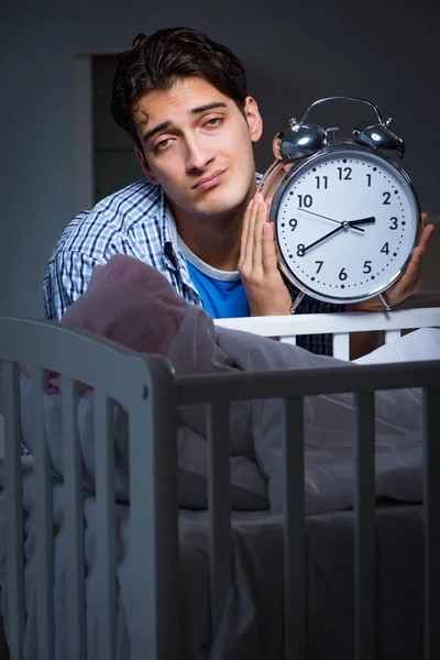 Молодий батько тато спить під час догляду за новонародженою дитиною — стокове фото