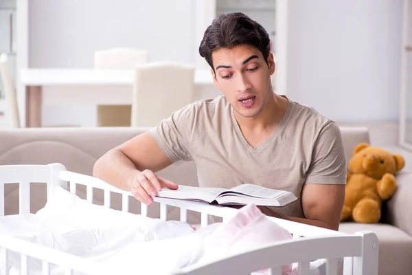 Young dad student preparing for exams and looking after baby — Stock Photo, Image