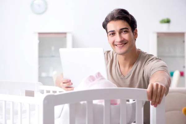 Young dad student preparing for exams and looking after baby — Stock Photo, Image