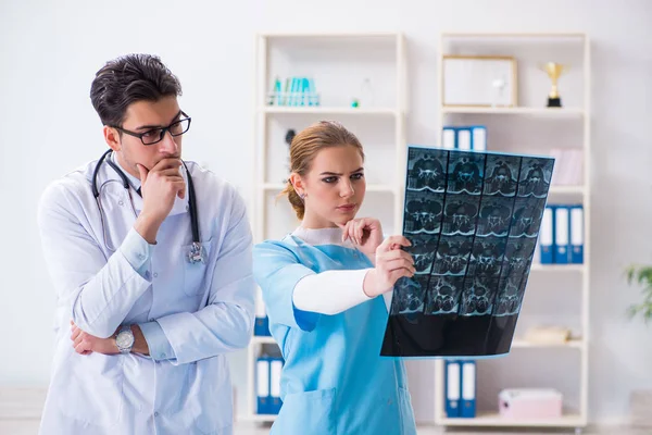 Due medici che esaminano le immagini a raggi X del paziente per la diagnosi — Foto Stock