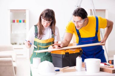 Ahşap atölyesinde kadın marangozluk ipuçlarını açıklayan adam