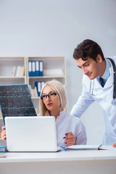 Zwei Ärzte untersuchen Röntgenbilder des Patienten zur Diagnose — Stockfoto