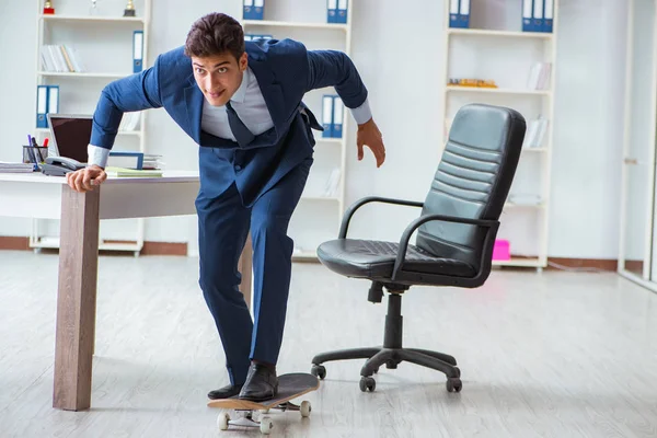 Молодой бизнесмен со скейтом в офисе в спортивной концепции — стоковое фото