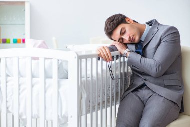 Genç iş adamı yeni doğmuş bebeğe evde bakmaya çalışıyor.