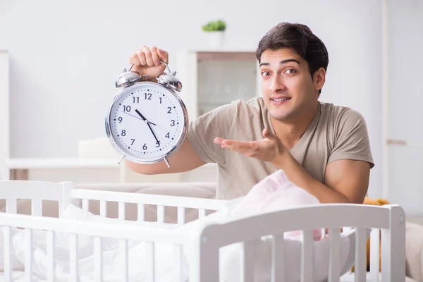 갓난아기 침대 근처에서 시계를 차고 있는 어린 아버지 — 스톡 사진