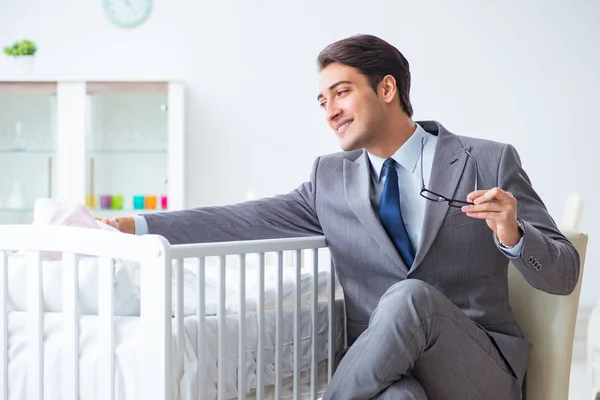 Joven hombre de negocios tratando de trabajar desde casa cuidando después del bebé recién nacido — Foto de Stock