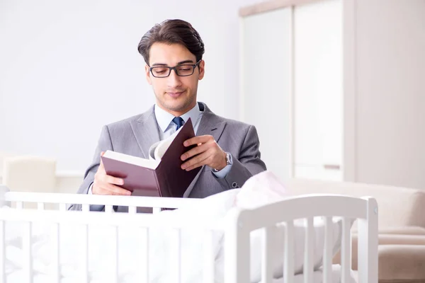 Joven hombre de negocios tratando de trabajar desde casa cuidando después del recién nacido — Foto de Stock