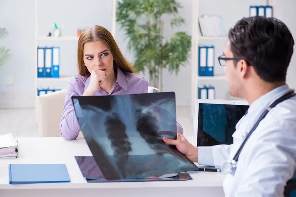 Läkare undersöker röntgenbilder av patienten — Stockfoto