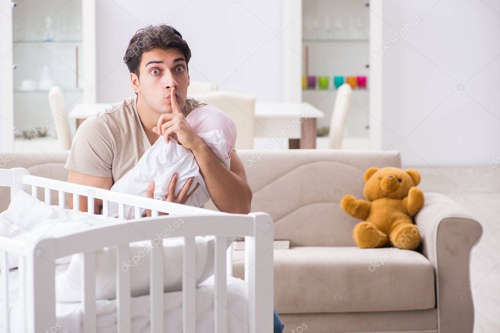 Young father enjoying time with newborn baby at home