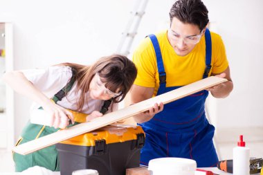 Ahşap atölyesinde kadın marangozluk ipuçlarını açıklayan adam