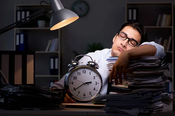Joven hombre de negocios trabajando horas extras hasta tarde en el cargo — Foto de Stock