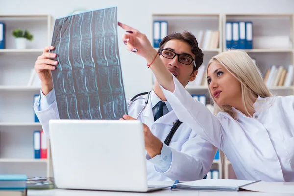 Två läkare undersöker röntgenbilder av patienten för diagnos — Stockfoto