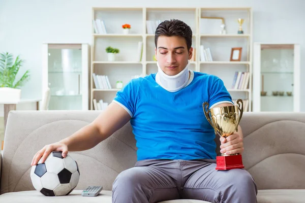 Boynundan sakatlanan bir adam evde futbol maçı izliyor. — Stok fotoğraf