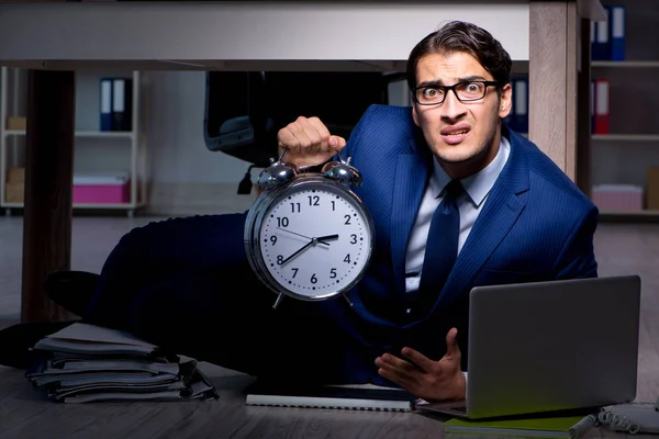 Businessman working overtime long hours late in office