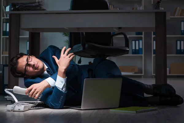 Uomo d'affari che fa gli straordinari lunghe ore in ritardo in ufficio — Foto Stock