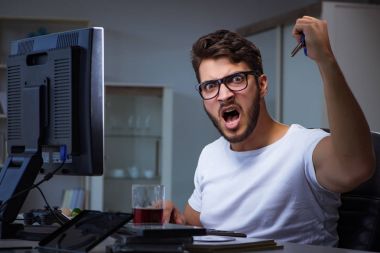 Genç adam fazla mesai yapmak için geç saatlere kadar ofiste kalıyor.