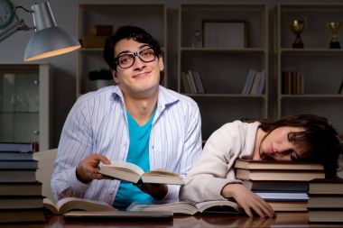 İki öğrenci geç saatlere kadar çalışıp sınavlara hazırlanıyor.