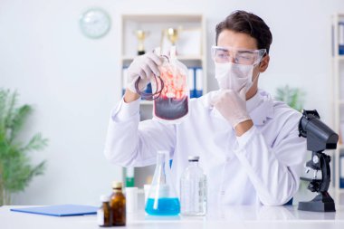 Hastane kliniğinde kan örnekleriyle çalışan bir doktor.