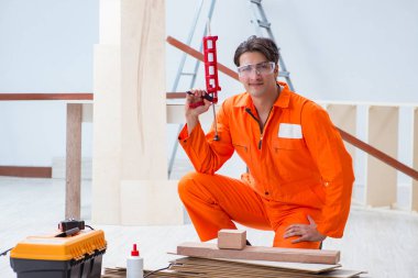 Müteahhit lamine ahşap zemin üzerinde çalışıyor.