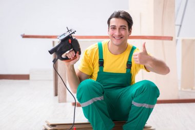 Müteahhit lamine ahşap zemin üzerinde çalışıyor.