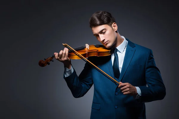 Young man playing violin in dark room — Stock Photo, Image