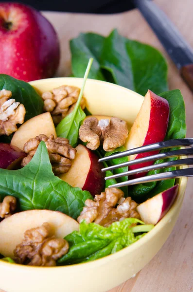 Salada de espinafre com nozes e maçãs servidas na mesa — Fotografia de Stock