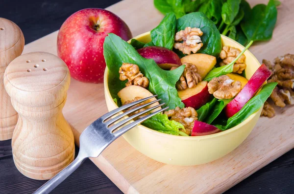 Salada de espinafre com nozes e maçãs servidas na mesa — Fotografia de Stock