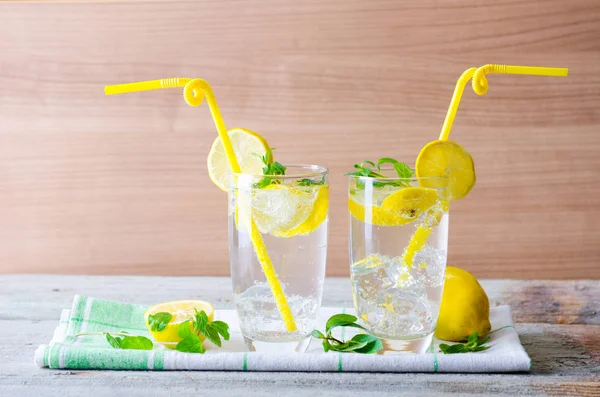 Glasss of mojito with lemon and drinking straw — Stock Photo, Image