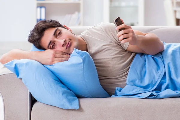 Muž závislý na svém mobilním telefonu v posteli — Stock fotografie