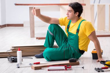 Müteahhit lamine ahşap zemin üzerinde çalışıyor.