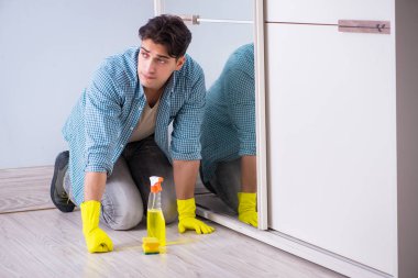 Otelde ayna temizleyen genç adam.