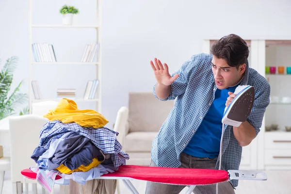 Ung man make gör kläder strykning hemma — Stockfoto