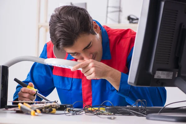 Professional repairman repairing computer in workshop