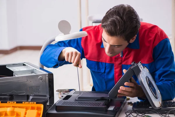 Professional repairman repairing computer in workshop