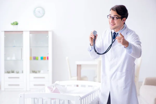 Man manlig barnläkare nära barnsäng förbereder sig för att undersöka — Stockfoto