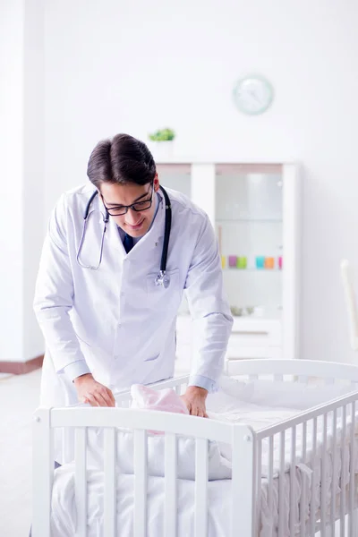 Homem pediatra masculino perto da cama do bebê se preparando para examinar — Fotografia de Stock