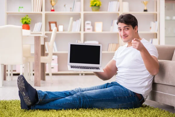 Homem trabalhando no laptop em casa no chão do tapete — Fotografia de Stock