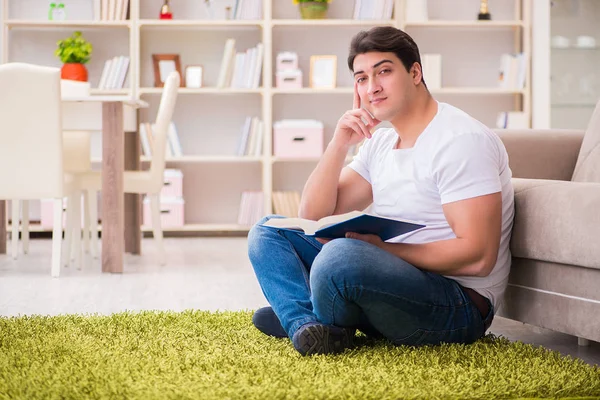 Homme lecture livre à la maison sur le sol — Photo