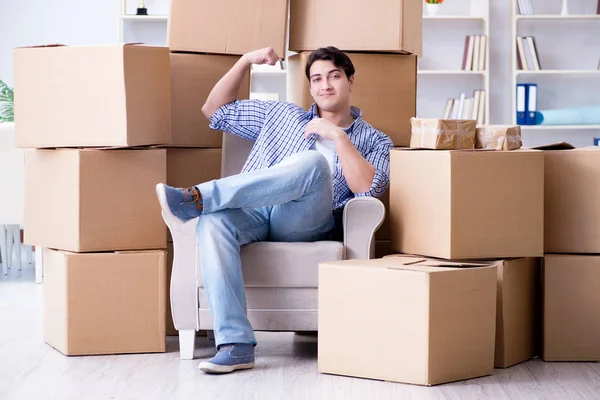 Молодий чоловік переїжджає в новий будинок з коробками — стокове фото