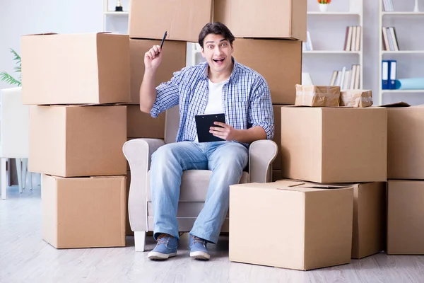 Jovem se mudando para casa nova com caixas — Fotografia de Stock