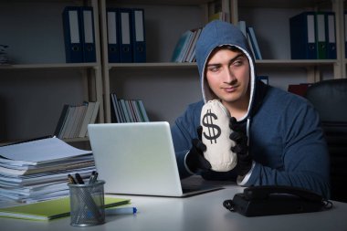 Genç hacker geceleri bilgisayarı hackliyor.