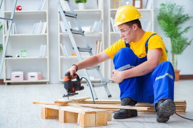 Ahşap palet montajı yapan genç adam.